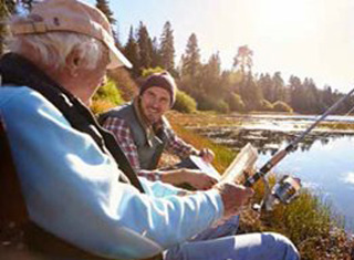White haired man fishing with younger man